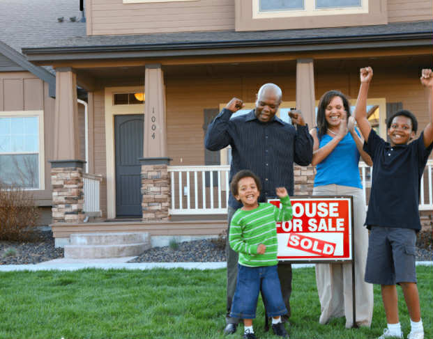 Family in front of a new home representing housing assistance
